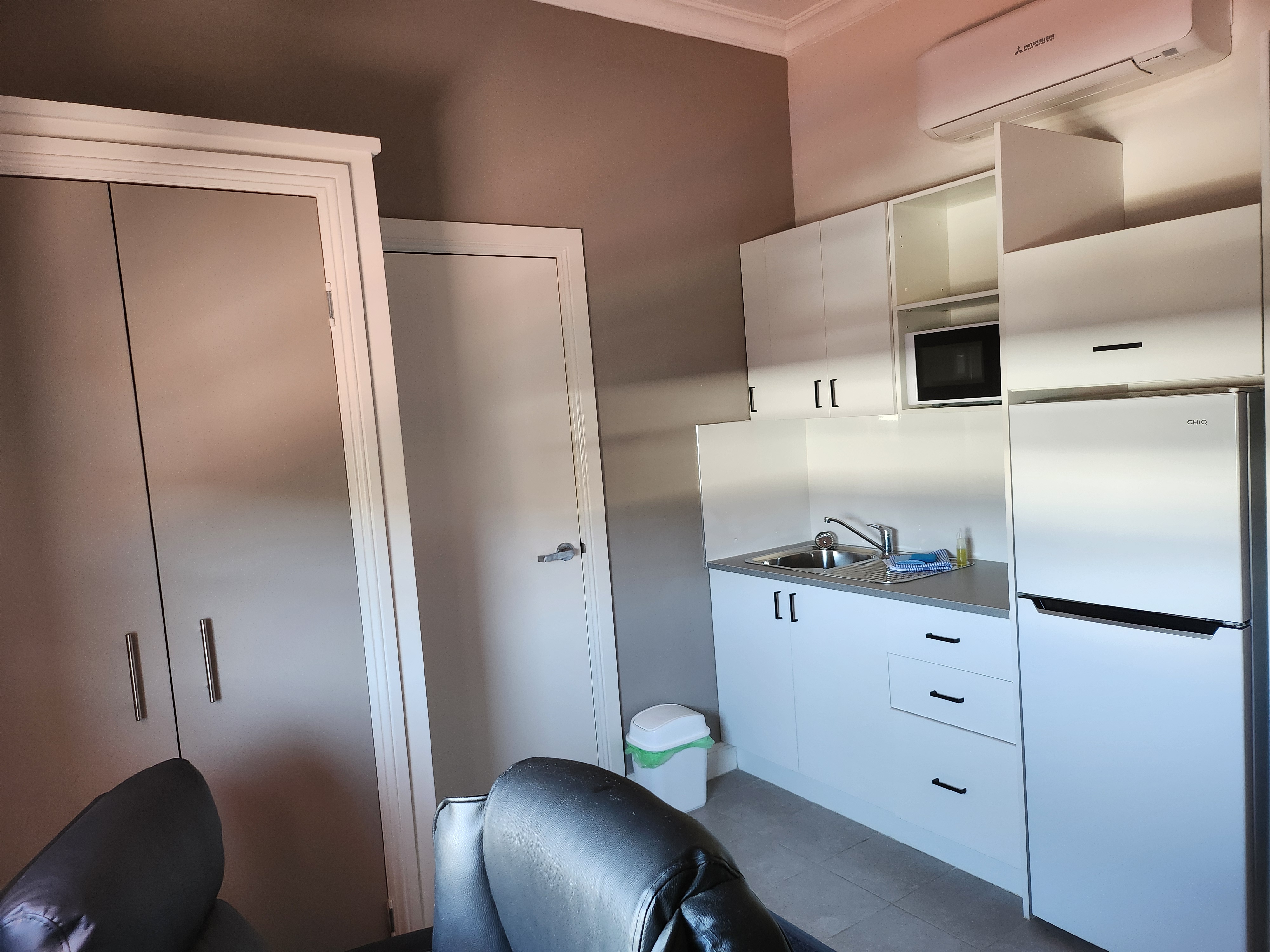 In-room kitchenette with air conditioning, microwave, sink, and fridge/freezer